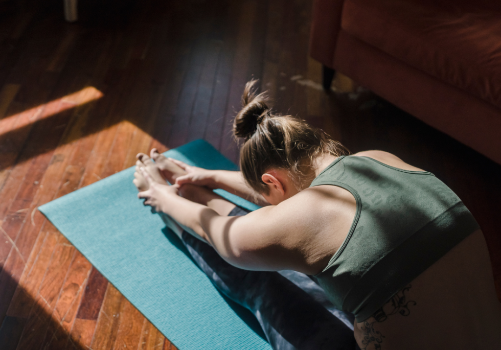 Woman doing forward fold yoga pose after a workout