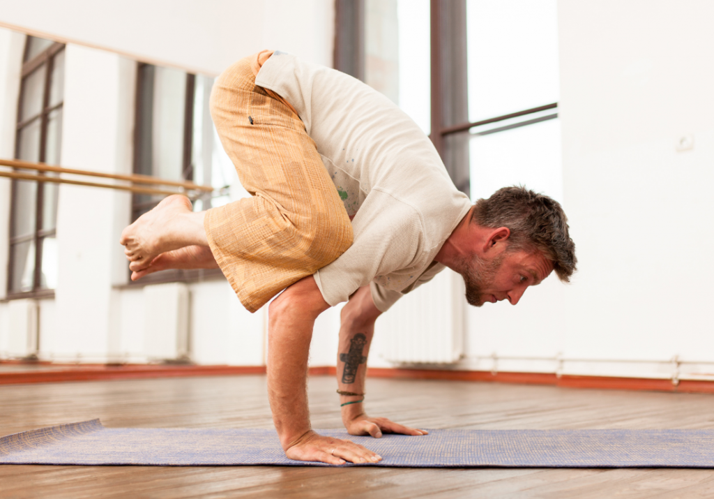 Man playing in yoga crow pose after a workout