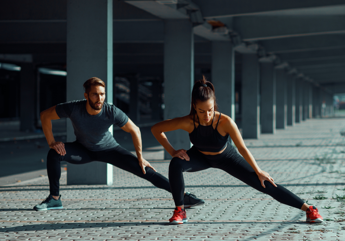 Two people doing an adductor stretch